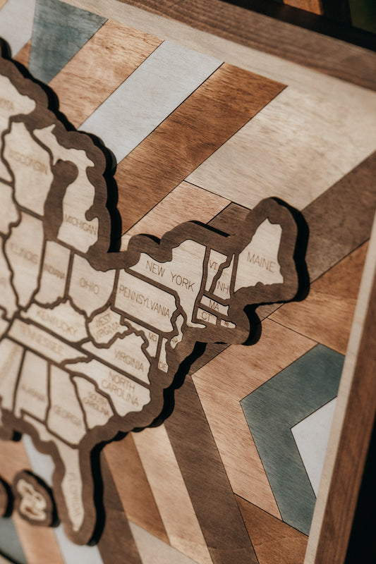 Close-up of Heritage Quilt wooden travel map highlighting states and handcrafted geometric quilt background