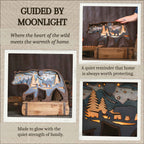 A collage-style product presentation for a wooden bear-shaped night light with a forest and cabin cutout design. The main panel shows the lit product on a wooden base against a dark background, with text reading 'GUIDED BY MOONLIGHT.