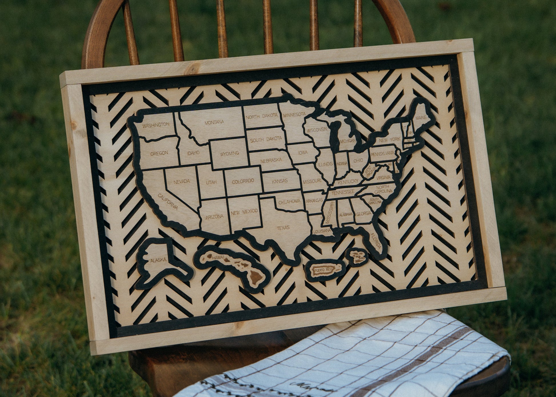 Full view of the Hearthline Series wooden USA travel map displayed on a rustic wooden chair, ideal for wall décor and memory tracking.