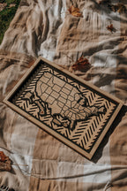 Lifestyle image of the Hearthline Series wooden USA travel map resting on a cozy autumn blanket, symbolizing journeys, memories, and heritage.