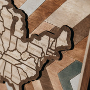 Close-up of Heritage Quilt wooden travel map highlighting states and handcrafted geometric quilt background