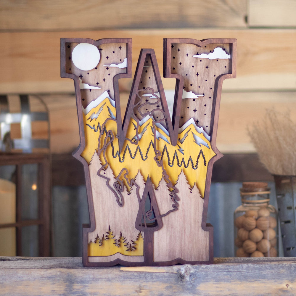 University of Wyoming scene inlaid in the iconic "W" with mountains and a steamboat