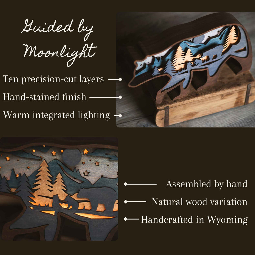 Laser-cut wooden bear-shaped night light with integrated warm lighting, shown on a dark background with feature callouts and text including 'Guided by Moonlight,' 'Ten precision-cut layers,' 'Hand-stained finish,' 'Warm integrated lighting,' 'Assembled by hand,' 'Natural wood variation,' and 'Handcrafted in Wyoming.'.