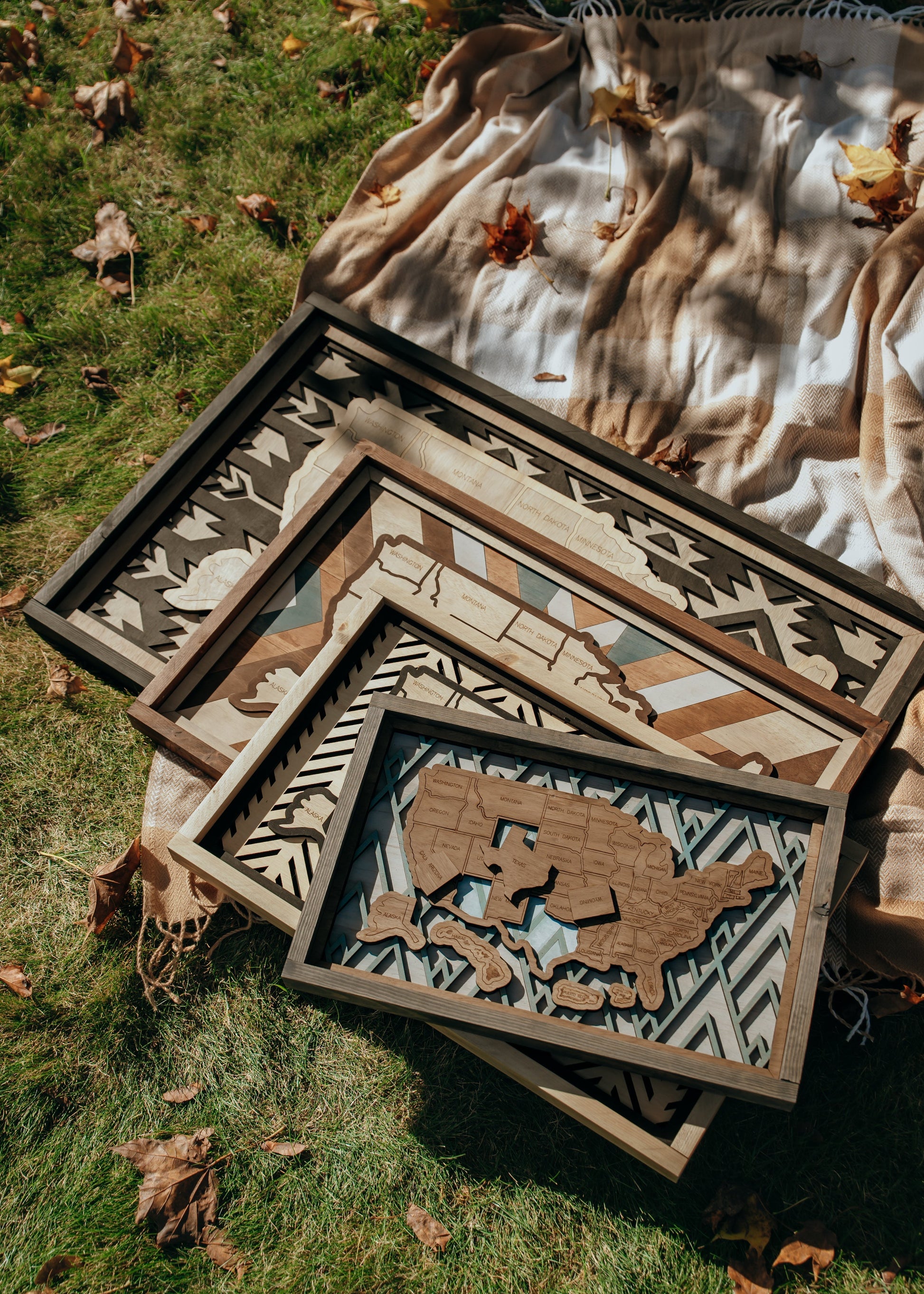 Handcrafted wooden USA travel maps in four sizes — Essential, Signature, Collector’s, and Heirloom — displayed together to show scale and detail.