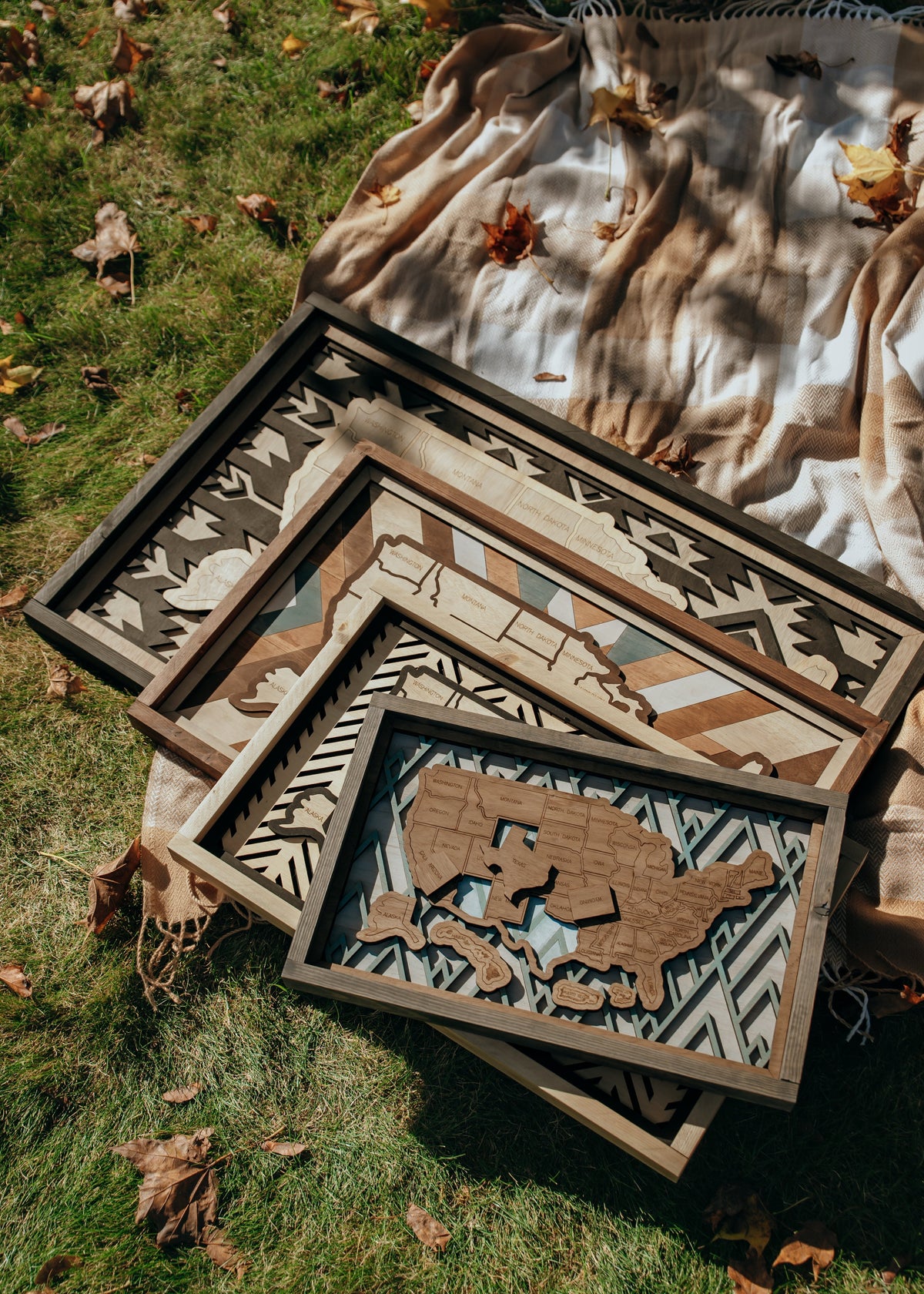 Handcrafted wooden USA travel maps in four sizes — Essential, Signature, Collector’s, and Heirloom — displayed together to show scale and detail.