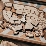 Handcrafted USA wooden travel map with removable state pieces and intricate quilt-inspired background design