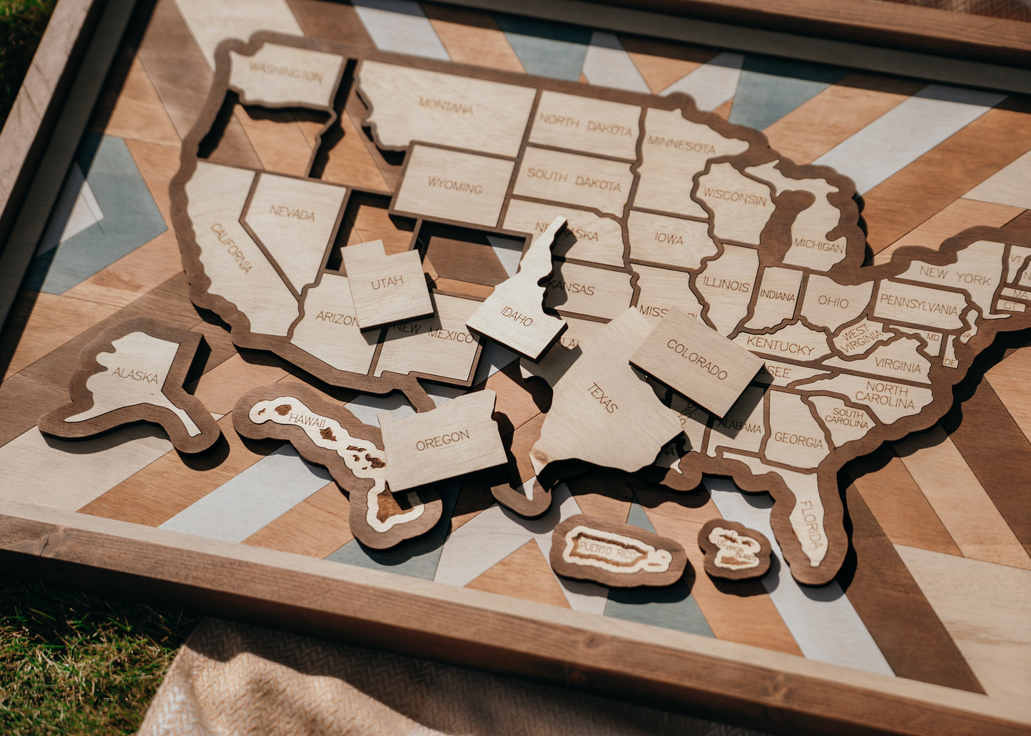 Handcrafted USA wooden travel map with removable state pieces and intricate quilt-inspired background design