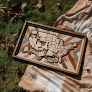 Overhead view of Heritage Quilt travel map laid on blanket outdoors, showcasing rustic tones and detailed wood grain