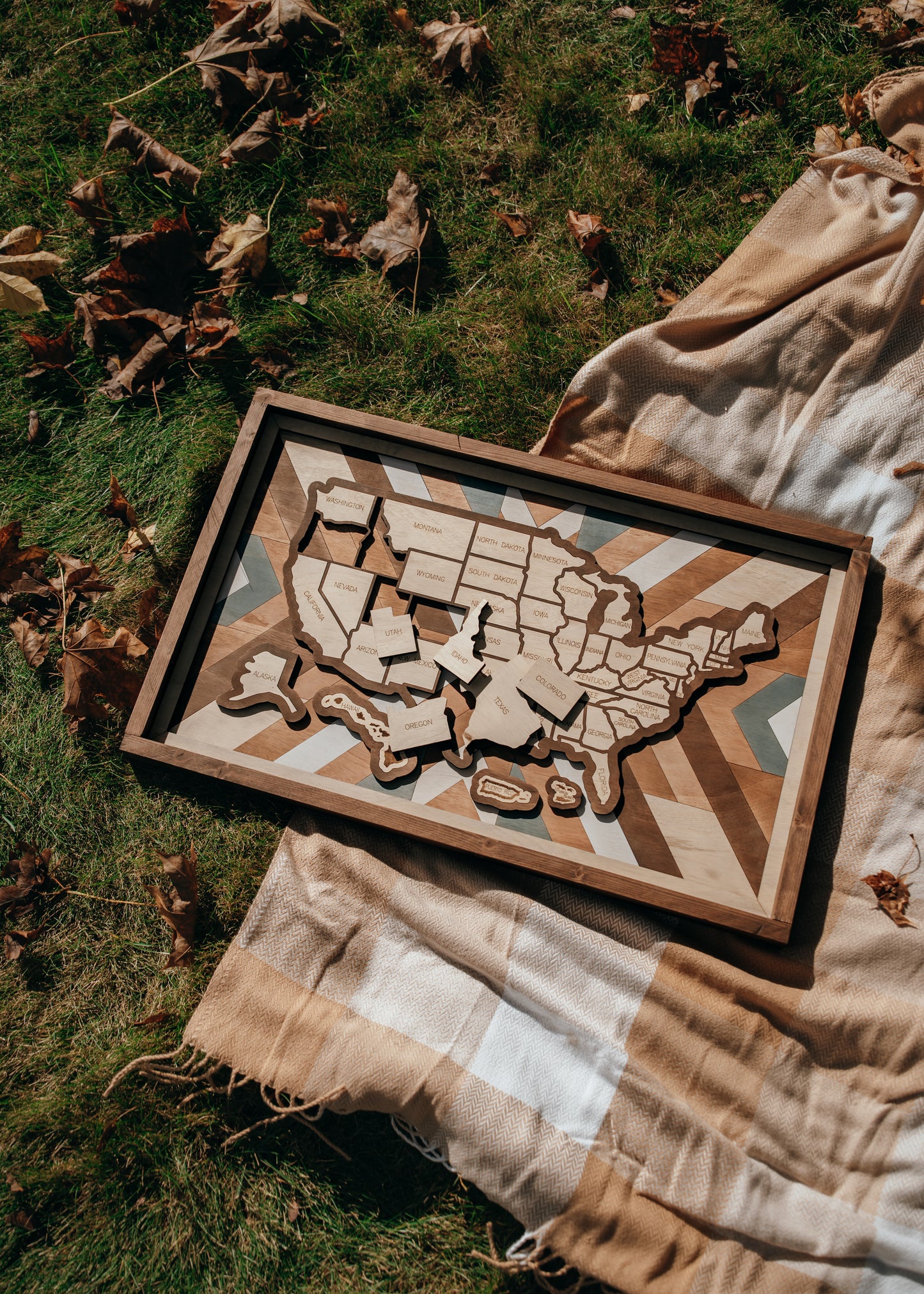 Overhead view of Heritage Quilt travel map laid on blanket outdoors, showcasing rustic tones and detailed wood grain