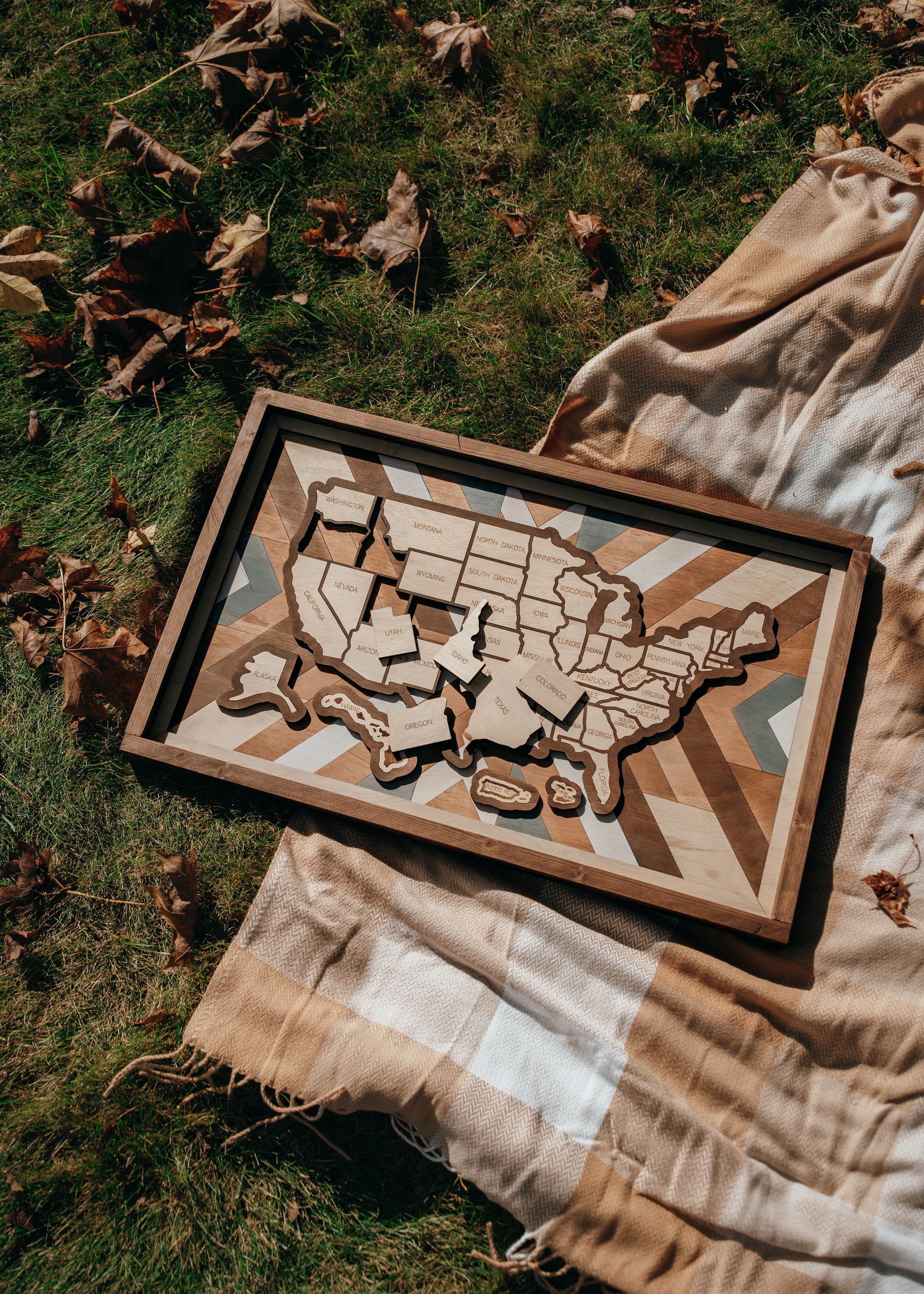Overhead view of Heritage Quilt travel map laid on blanket outdoors, showcasing rustic tones and detailed wood grain