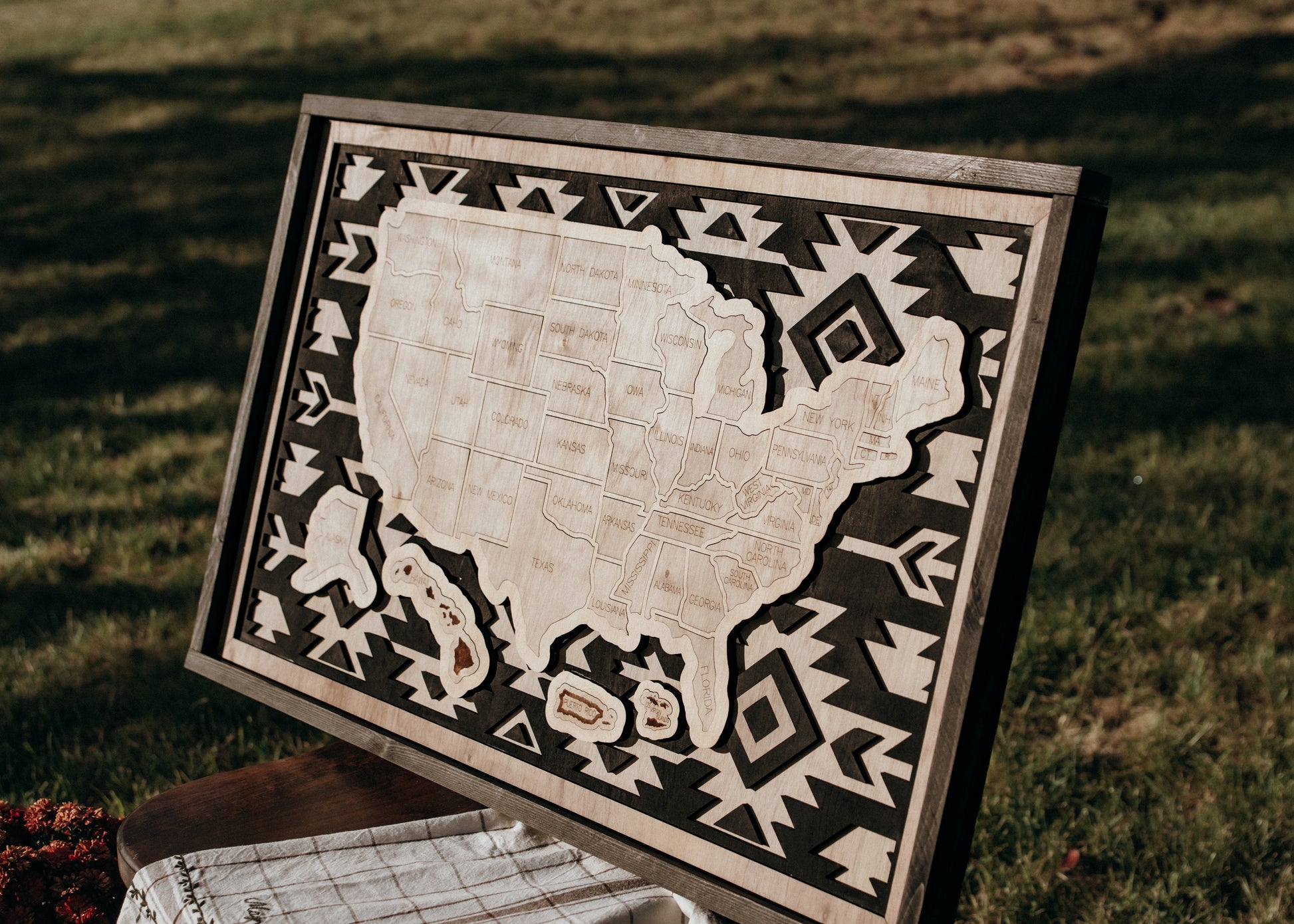 Angled view of the Heritage Trails Storyline Series wooden travel map showcasing engraved states and layered geometric border.