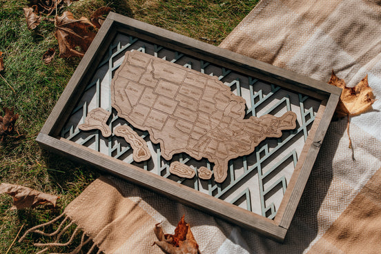 Full view of the Summit Peaks handcrafted wooden USA travel map from the Storyline Series, styled outdoors with rustic accents.