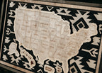 Detailed view of a handcrafted wooden USA travel map from the Storyline Series, featuring engraved states and bold geometric background.